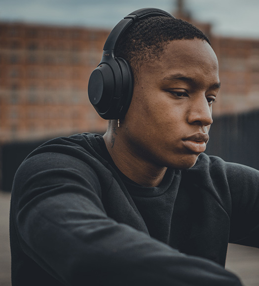 Man wearing over-ear headphones, looking down