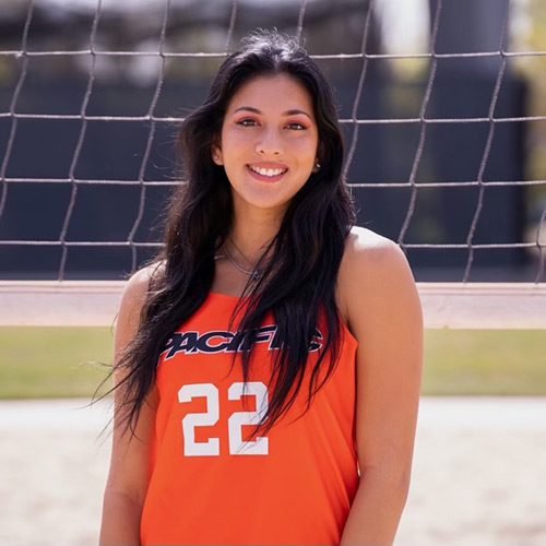 Hania posing in front of volleyball net and smiling