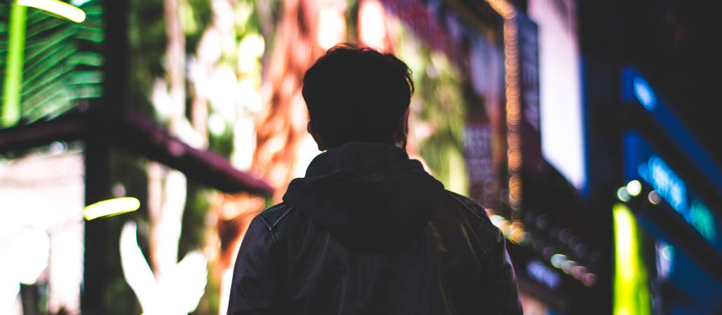 Man in street, neon lights in background