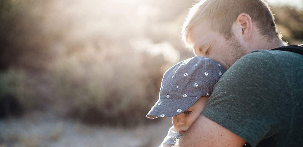 Man hugging infant son