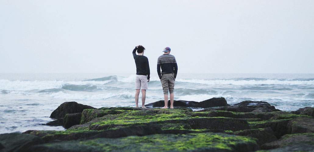 Two men talking on beach