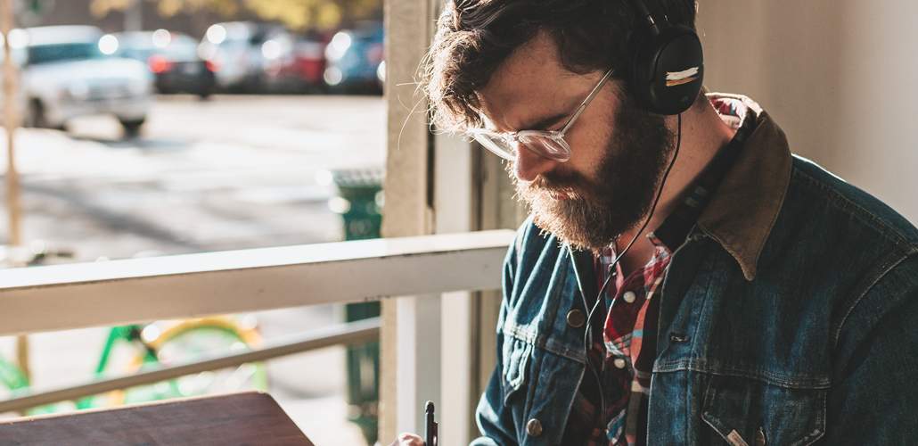 Man with beard and glasses at desk